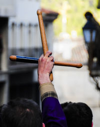 Cropped hand raised with wooden sticks during holy week