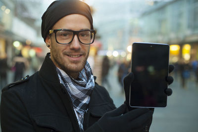 Portrait of young man using smart phone in city