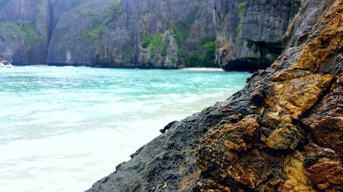 Close-up of rock by sea against sky