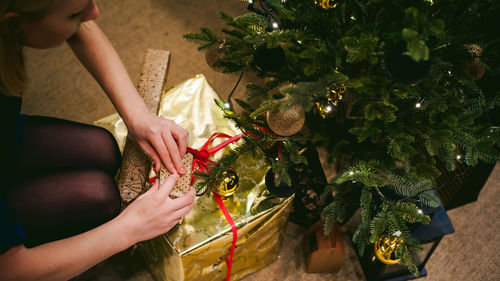 Close-up of woman decorating christmas tree at home