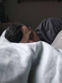 Close-up of young woman relaxing on bed at home