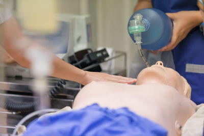 Midsection of paramedics with cpr dummy at hospital