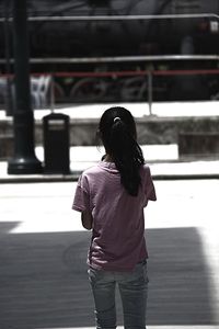 Rear view of girl standing on street