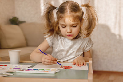 Girl sitting on table at home