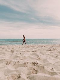 Full length of man on beach against sky