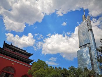 Low angle view of buildings against cloudy sky