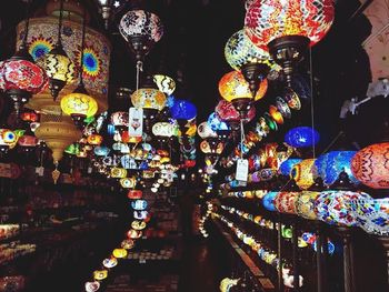 Illuminated lanterns hanging at market stall