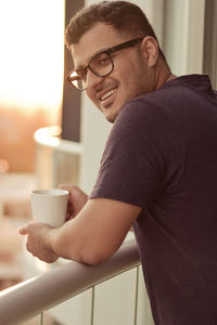 Close-up of man holding coffee cup at home