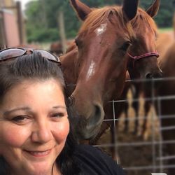 Portrait of smiling woman with horse at farm