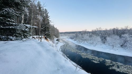 Snow covered landscape against clear sky