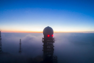 Scenic view of tower and buildings against sky during sunset