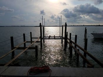 Pier over sea against sky during sunset