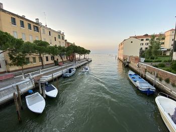 Canal amidst buildings in city against sky