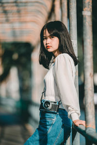 Young woman looking down while standing outdoors