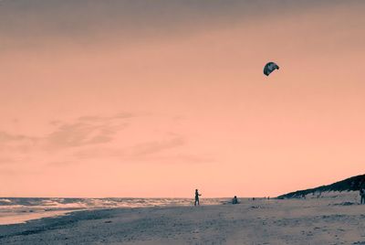 Person paragliding over sea