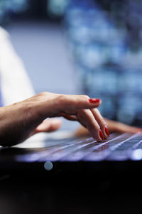 Cropped hand of woman using laptop