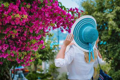 Rear view of woman wearing hat against plants