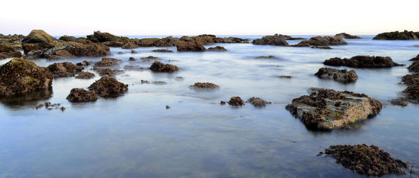 Scenic view of rocks in sea against sky