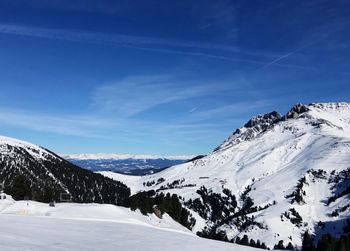 Scenic view of snowcapped mountains against blue sky