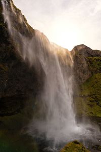 Scenic view of waterfall against sky