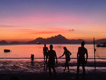 Silhouette people at beach during sunset