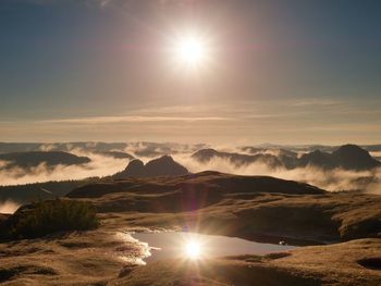 Water pool on cracked mountain summit. fairy daybreak in beautiful hills. peaks of hills in mirror