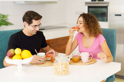 Young woman having food at home