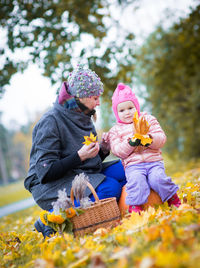 Mother with cute baby girl at park during autumn