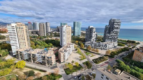 High angle view of buildings by sea against sky