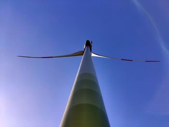 Low angle view of wind turbine against blue sky