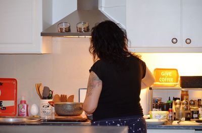 Rear view of woman standing at home