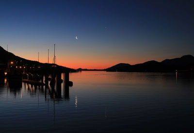 Scenic view of lake against clear sky at sunset