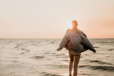 Rear view of shirtless man on beach