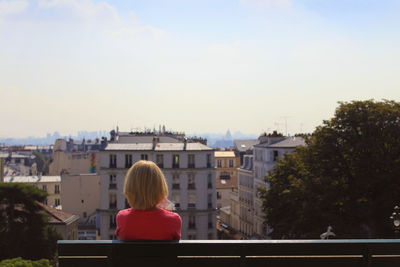 Rear view of woman against cityscape