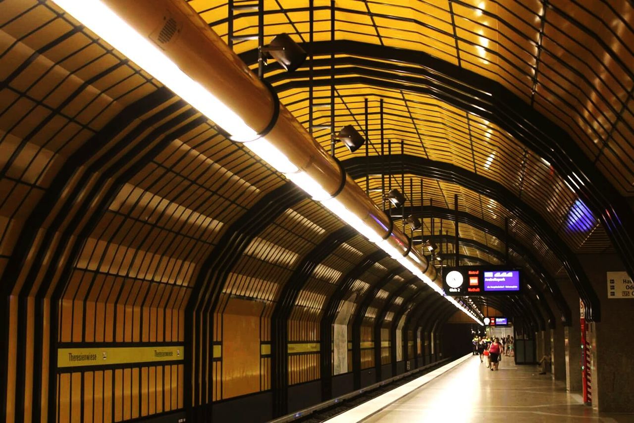 ceiling, architecture, arch, railroad station, built structure, public transportation, the way forward, subway station, illuminated, subway, tunnel, diminishing perspective, interior, transportation building - type of building, empty, underground, escalator, modern, vanishing point, architectural column