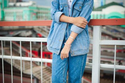 Midsection of woman standing by railing