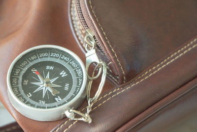 Close-up of navigational compass key ring on bag