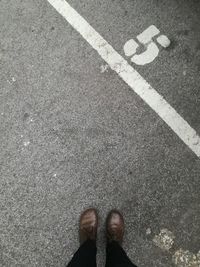 Low section of man standing on road