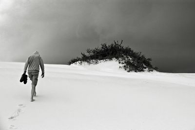 Man walking in desert against sky