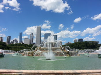 Fountain in city against sky