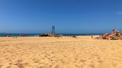 Scenic view of beach against clear blue sky