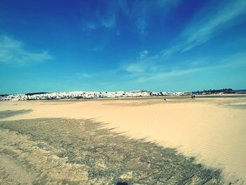 Scenic view of beach against blue sky
