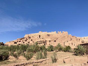 Built structure on landscape against blue sky