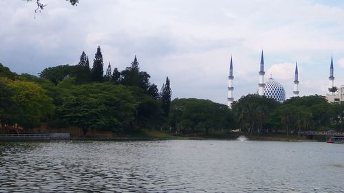 Scenic view of river by trees against sky