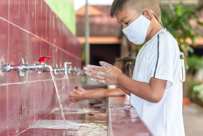 Side view of boy holding water