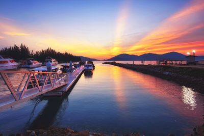 View of boats moored at harbor during sunset