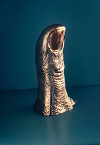 Close-up of figurine on table against blue background