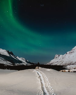 Scenic view of snowcapped mountains against sky at night