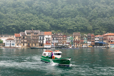 Boat in river by buildings in city