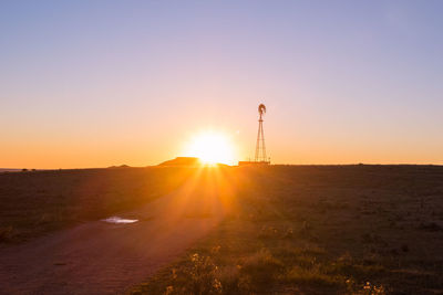 Scenic view of field against clear sky during sunset